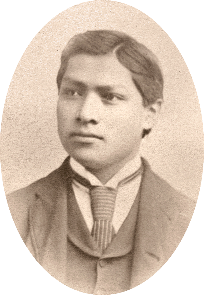 Carlos Montezuma in 1888, with short dark hair parted to the side, wearing a dark suit jacket, vest, white shirt, and striped tie.