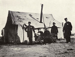 George Streeter (seated with top hat) sits with his wife outside their tent, 1902. Via Internet Archive.