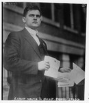 Roosevelt's stenographer Elbert Martin holds Roosevelt's bullet-pierced speech. Via the Library of Congress.