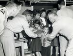 Quarantine inspectors check Cuban refugee children for vaccination marks, 1965. Via the National Library of Medicine.