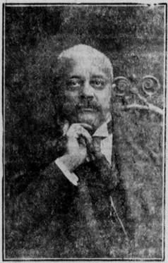 Portrait of Henderson sitting in an ornate chair with his right hand resting against his chin.