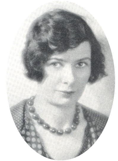 White woman with brown bobbed hair wearing necklace and patterned clothes, posing for her portrait