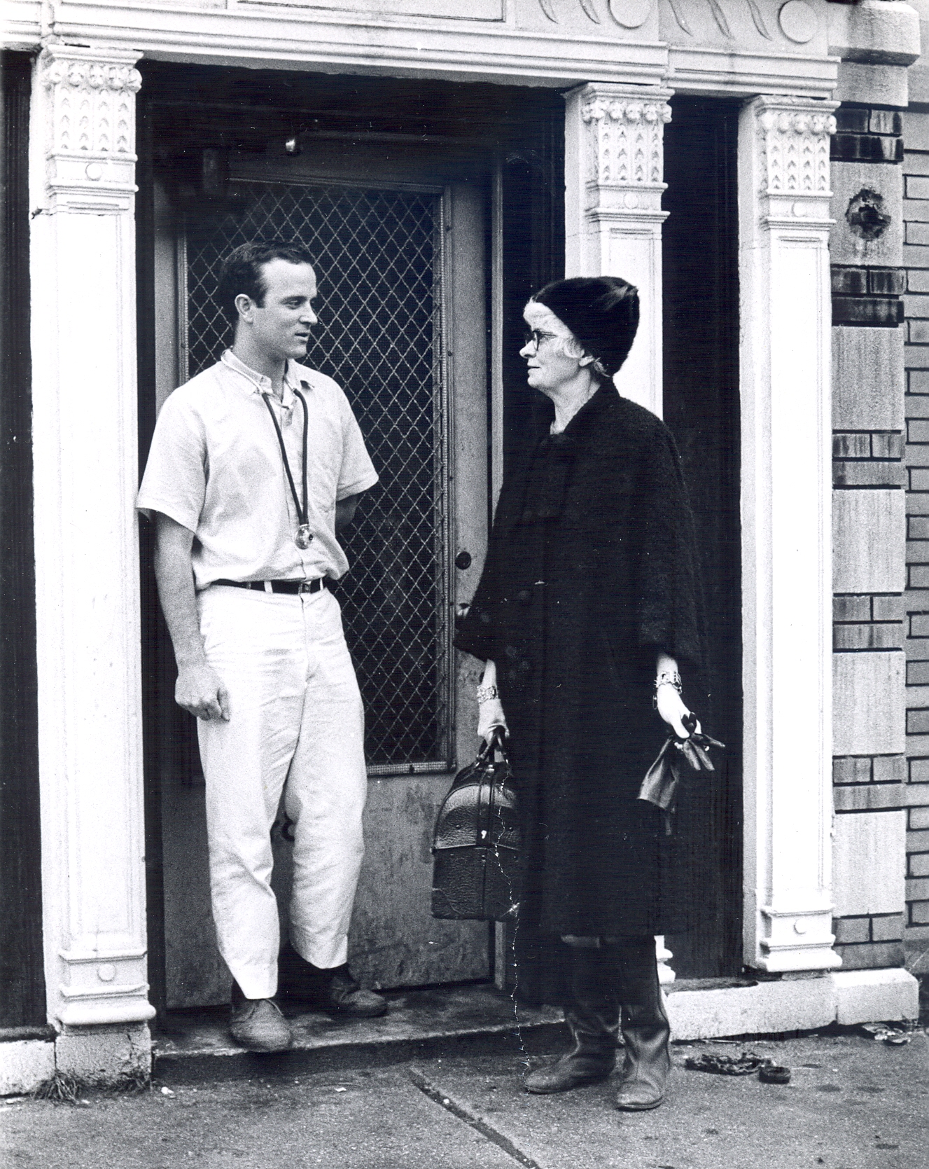 Beatrice Tucker carrying her medical bag standing with medical student outside of the Chicago Maternity Center